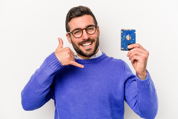 Homem caucasiano de informática jovem isolado no fundo branco, mostrando um gesto de chamada de celular com os dedos