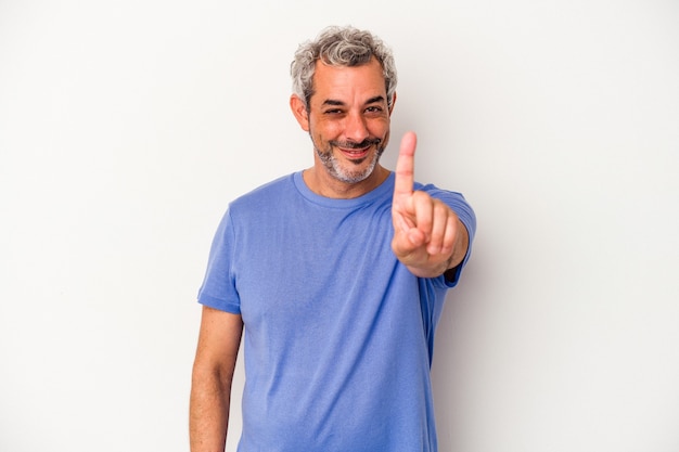 Homem caucasiano de meia-idade, isolado no fundo branco, mostrando o número um com o dedo.