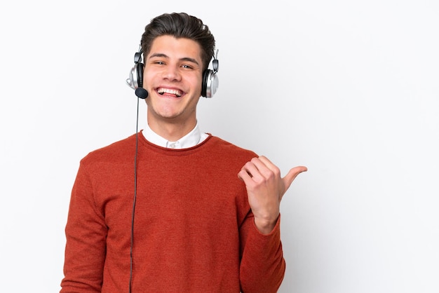 Homem caucasiano de telemarketing trabalhando com um fone de ouvido isolado no fundo branco, apontando para o lado para apresentar um produto