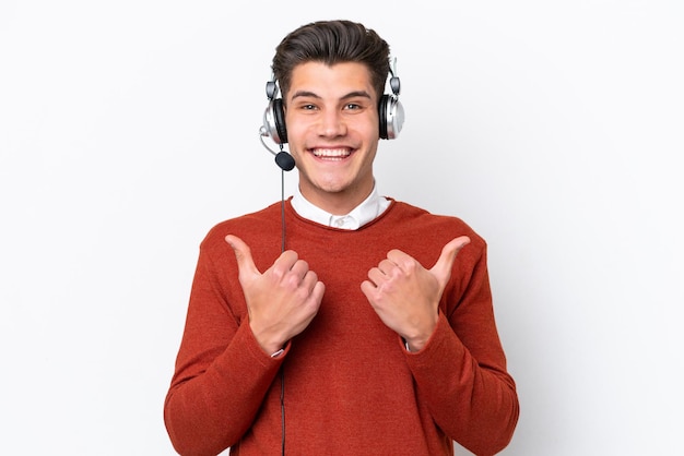 Homem caucasiano de telemarketing trabalhando com um fone de ouvido isolado no fundo branco com polegares para cima gesto e sorrindo
