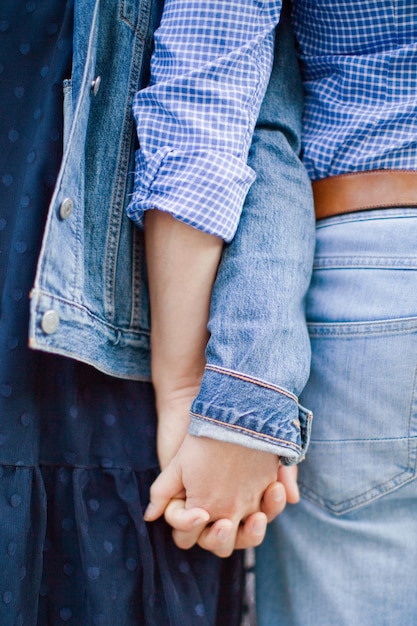 Foto homem caucasiano e mulher de mãos dadas jovem casal caucasiano vestindo roupas jeans e de mãos dadas ao ar livre