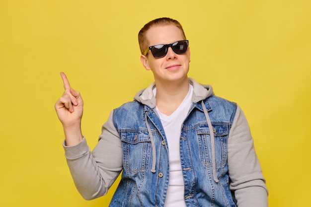 Homem caucasiano elegante em um jeans e óculos de sol amarelo