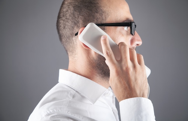 Homem caucasiano, falando no telefone do escritório.