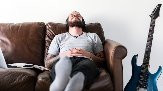 Homem caucasiano, fazendo uma pausa do trabalho, ouvindo o conceito de alívio de estresse de música