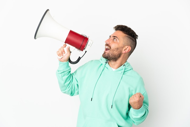 Homem caucasiano isolado no fundo branco gritando em um megafone para anunciar algo em posição lateral