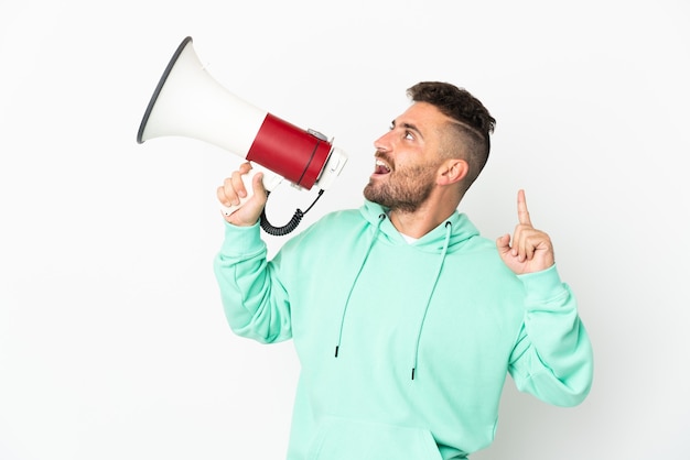 Homem caucasiano isolado no fundo branco gritando em um megafone para anunciar algo em posição lateral