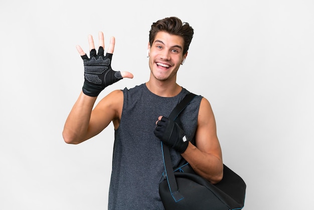 Homem caucasiano jovem esporte com bolsa esportiva sobre fundo branco isolado, contando cinco com os dedos