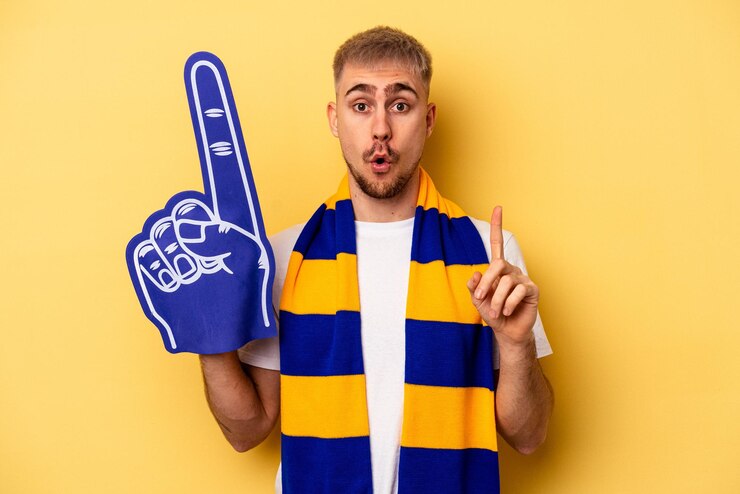 Foto homem caucasiano jovem fã de esportes isolado em fundo amarelo, tendo uma ótima ideia, conceito de criatividade.