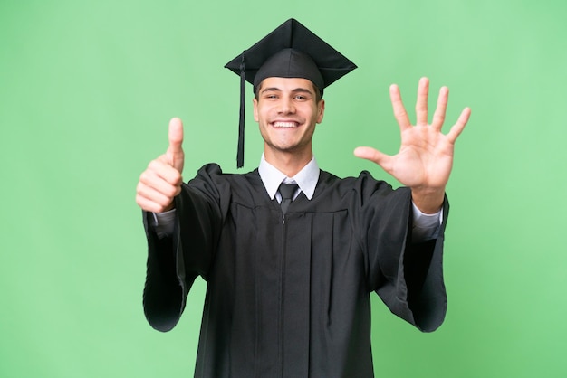 Homem caucasiano jovem universitário graduado sobre fundo isolado, contando seis com os dedos