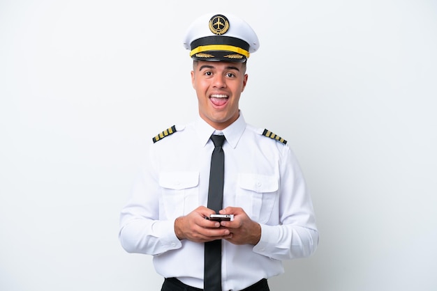 Homem caucasiano piloto de avião isolado no fundo branco surpreso e enviando uma mensagem