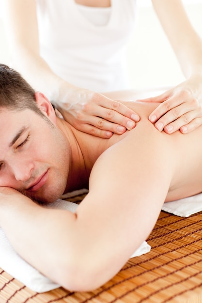 Foto homem caucasiano positivo com uma massagem nas costas em um centro de spa