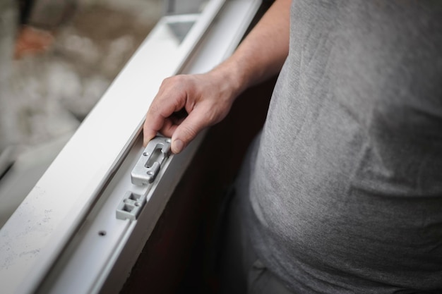 Homem caucasiano segurando acessórios para uma moldura de janela