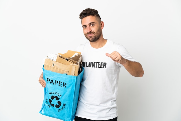 Homem caucasiano segurando uma sacola cheia de papel para reciclar isolado no fundo branco orgulhoso e satisfeito