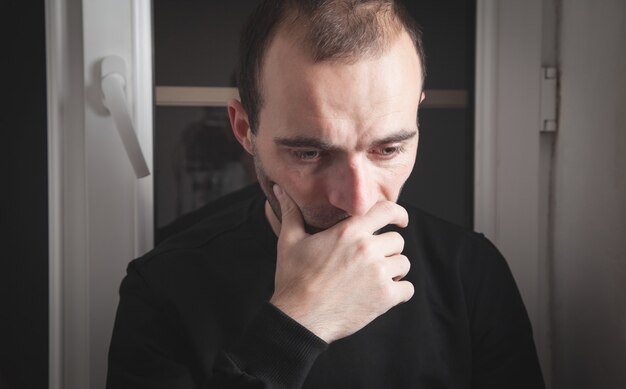 Homem caucasiano triste e deprimido em casa.