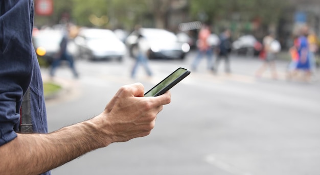 Homem caucasiano usando smartphone na cidade