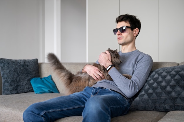 Foto homem cego acariciando e segurando seu gato