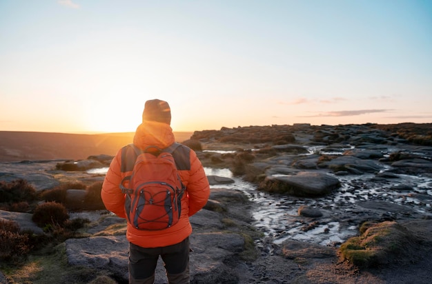 homem chegando ao destino no topo da colina ou montanha ao nascer do sol Conceito de turismo local