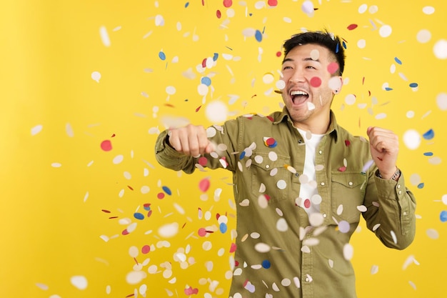 Foto homem chinês feliz rodeado de confetes voando no ar