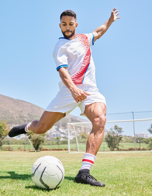 Homem chuta futebol e treinamento de futebol no campo esportivo ao ar livre para jogo de competição ou treino Motivação de objetivo de exercício físico e pernas fortes de atleta ou esporte de estilo de vida na grama do estádio