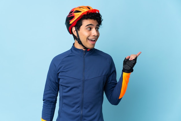 Homem ciclista venezuelano isolado no azul com a intenção de descobrir a solução enquanto levanta um dedo