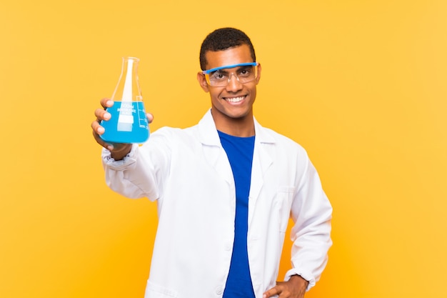 Homem científico segurando um balão de laboratório sobre parede isolada