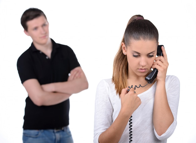 Homem ciumento por trás das mulheres que falam ao telefone.