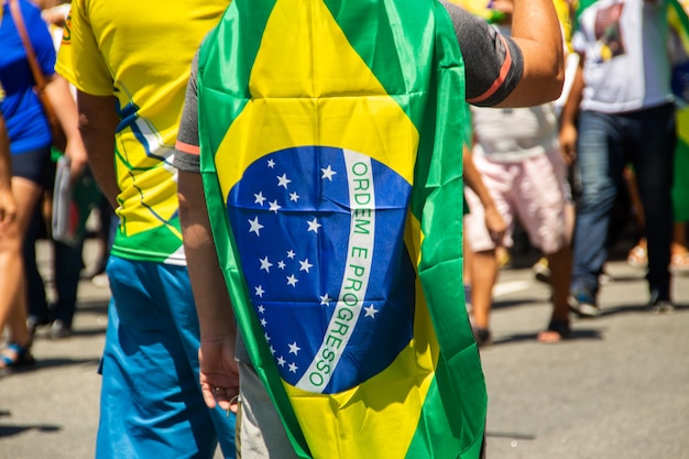 Homem com a bandeira do Brasil durante uma marcha no Rio de Janeiro