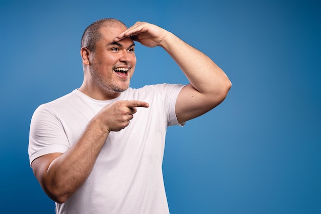 Foto homem com a mão na testa a ver algo.