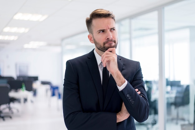 Foto homem com a mão no queixo pensando