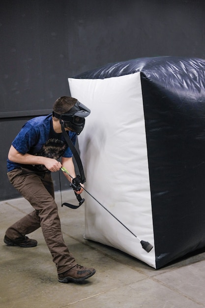 Foto homem com arco de flechas de besta. o arqueiro mira, atirador. clube de besta.