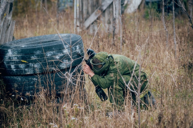 Homem com arma jogando paintball. ao ar livre