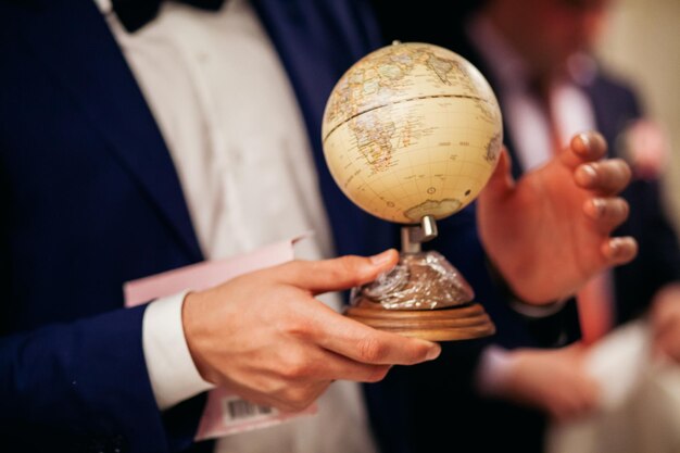 Homem com atlas mundial. o homem escolhe o país no atlas mundial.