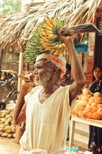 Foto homem com bananas à venda