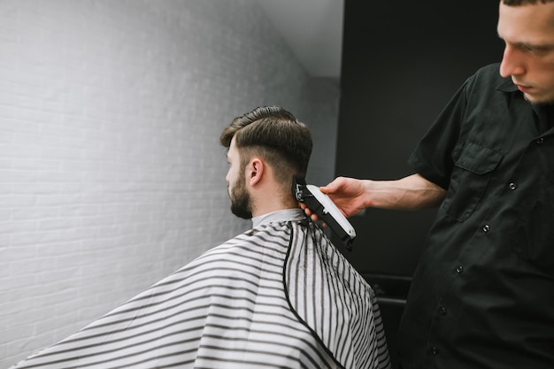 Homem com barba e cabelo na barbearia Corte de cabelo em um barbeiro profissional Fundo