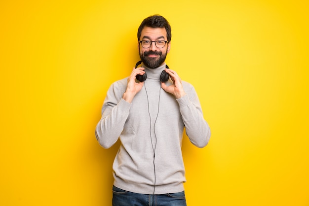 Homem com barba e gola alta com fones de ouvido