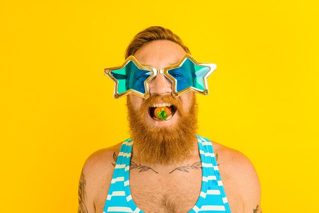 Homem com barba e óculos de sol comendo morango