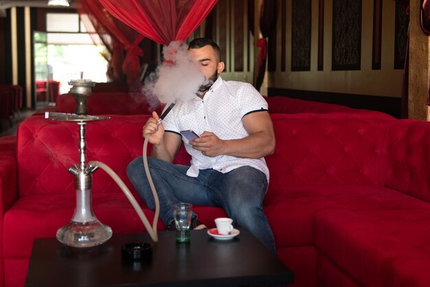 Homem com barba relaxa fumar Shisha