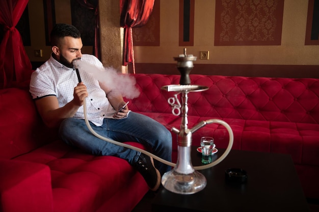 Homem com barba relaxa fumar Shisha