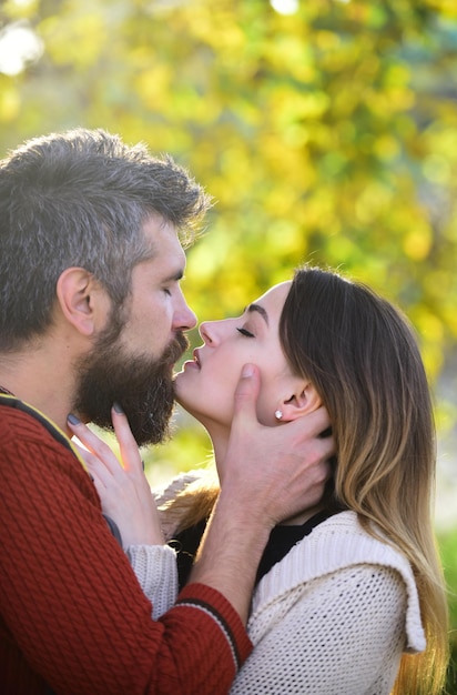 Foto homem com barba segura a cabeça da mulher com ternura, close-up.