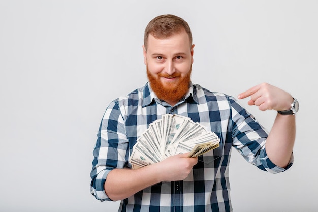 Homem com barba segurando muitas notas de cem dólares