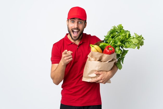 Homem com barba segurando uma sacola cheia de vegetais