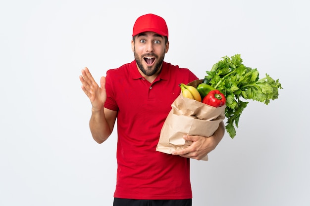Homem com barba segurando uma sacola cheia de vegetais