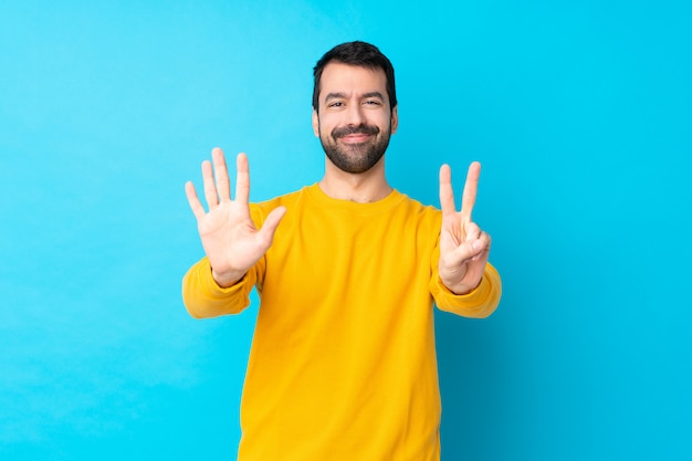 Homem com barba sobre parede azul isolada