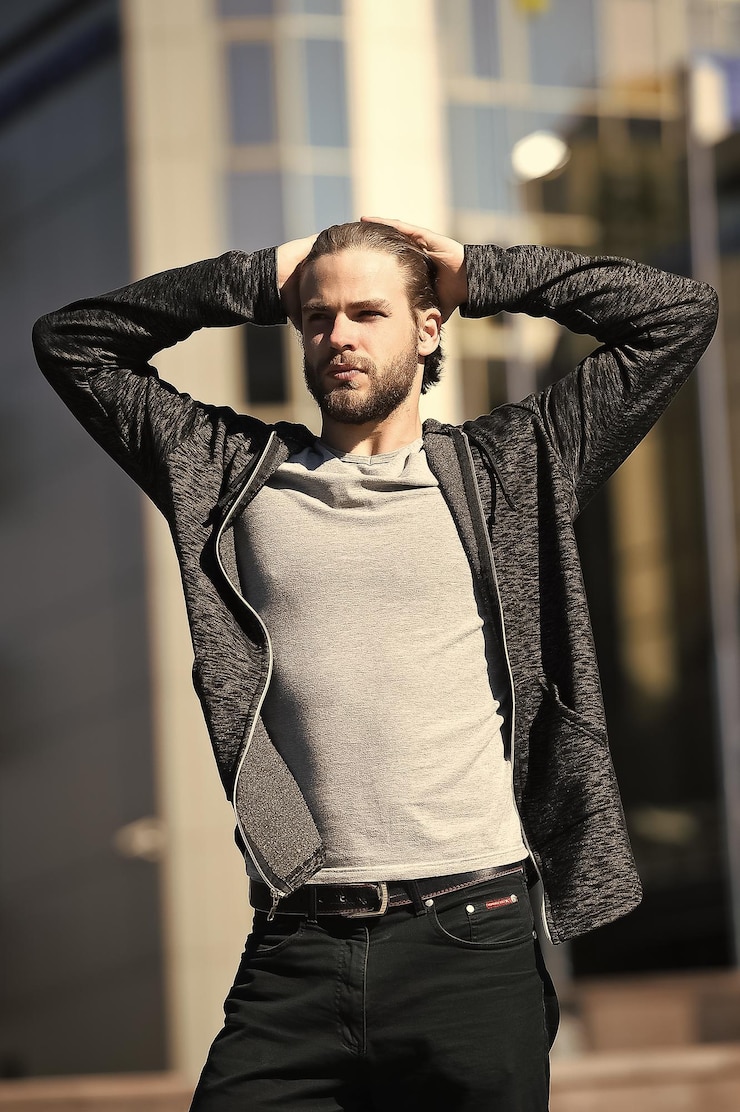 Foto homem com barba toca no cabelo com as mãos
