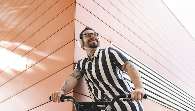 Homem com bicicleta e fones de ouvido feliz na rua