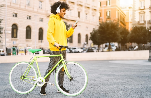 Foto homem com bicicleta usando telefone inteligente enquanto está de pé na rua
