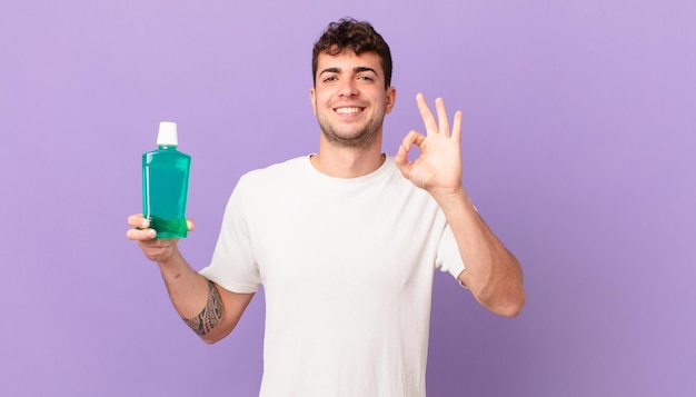 Homem com bochechos sentindo-se feliz, relaxado e satisfeito, mostrando aprovação com gesto de ok, sorrindo