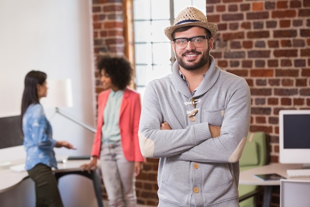 Homem, com, braços cruzaram, e, colegas, atrás, em, escritório