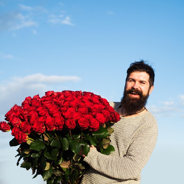 Homem com buquê de flores homem feliz segura um grande buquê de rosas vermelhas em casamento em casamento