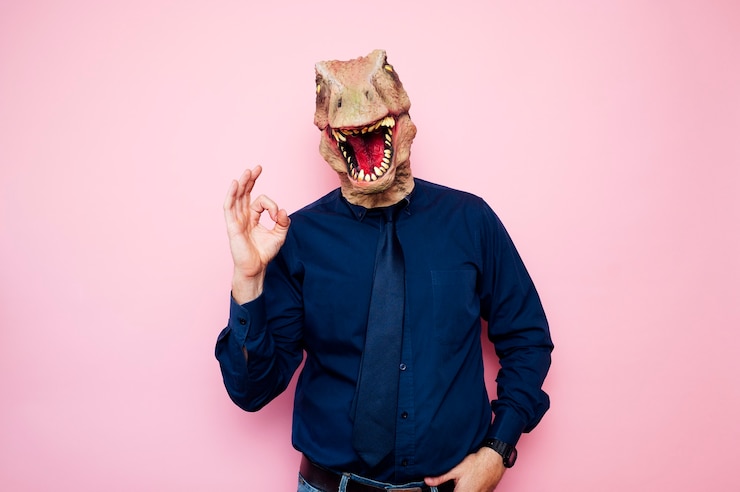 Foto homem com cabeça de dinossauro eufórico e dedos com o símbolo ok
